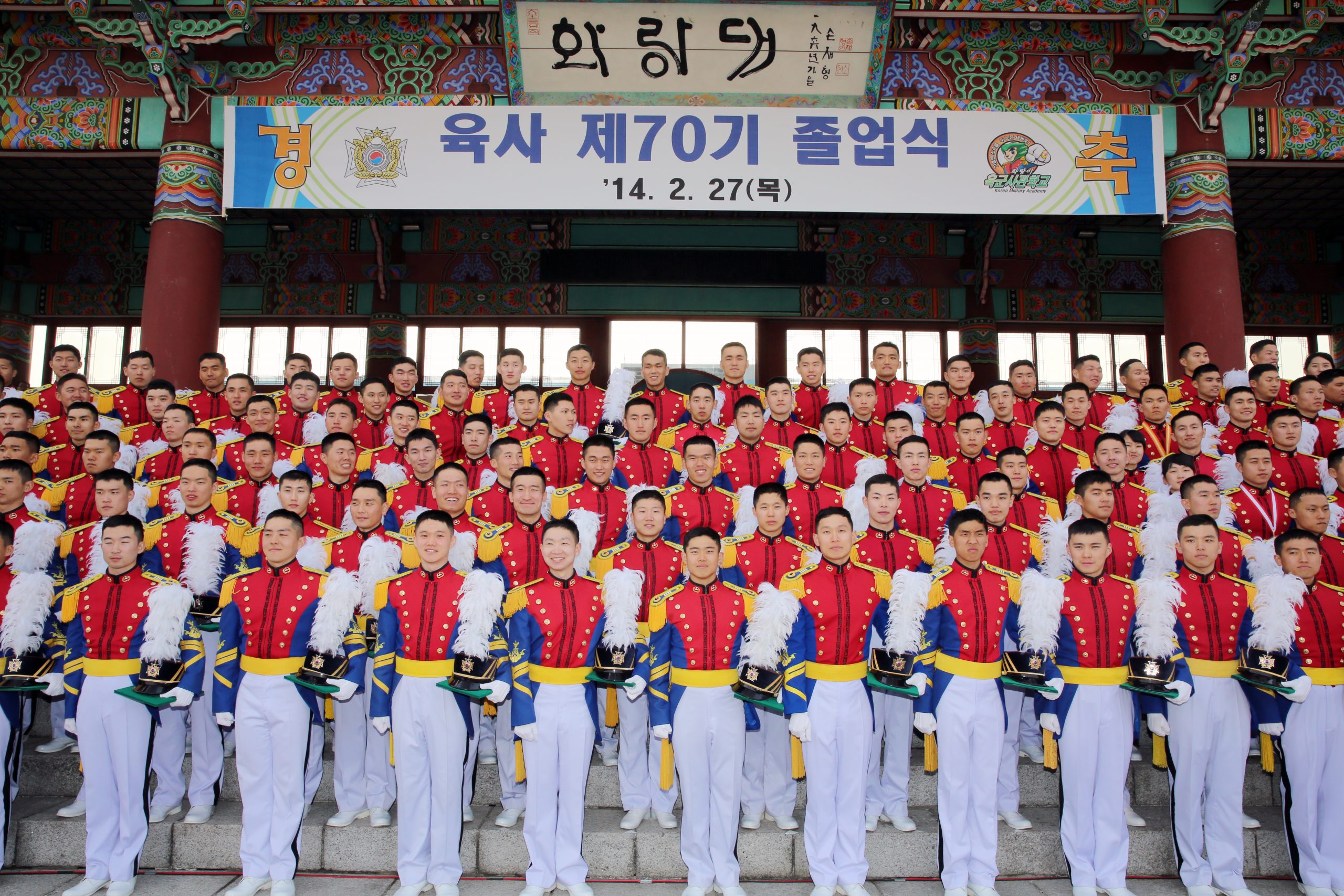 졸업식 현수막 아래에서 기념사진을 찍는 육군사관학교 졸업생들